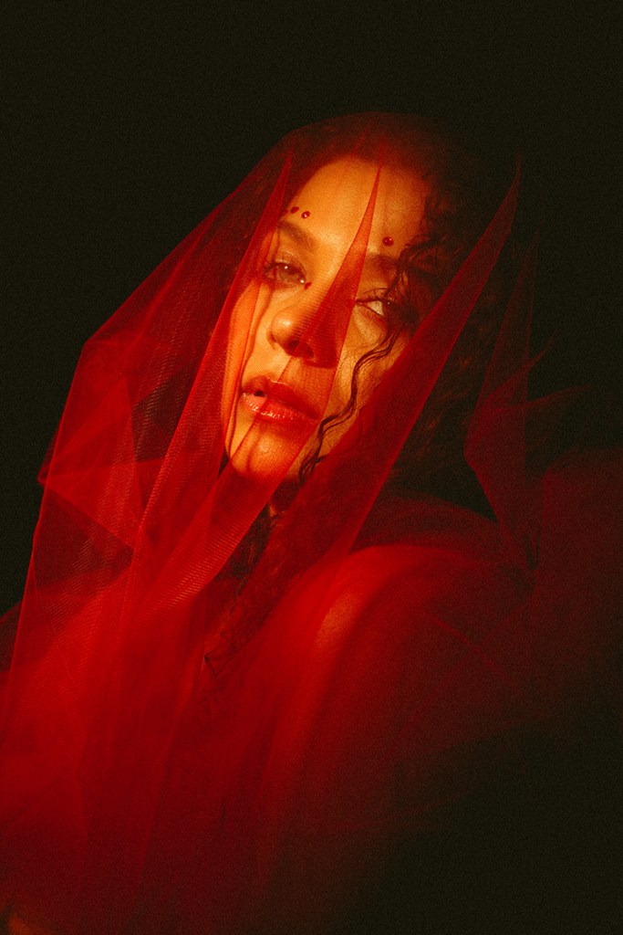 Dreamy girl wrapped in a red veil